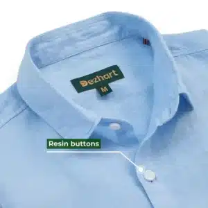 Close-up of a medium-sized Light blue Linen shirt with a label reading ‘DezHart’ and white resin buttons.”